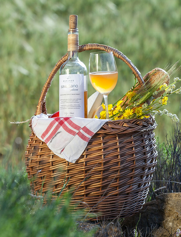 Picknickkorb mit Weißwein und Glas im Grünen – stilvolles Präsent für Genießer